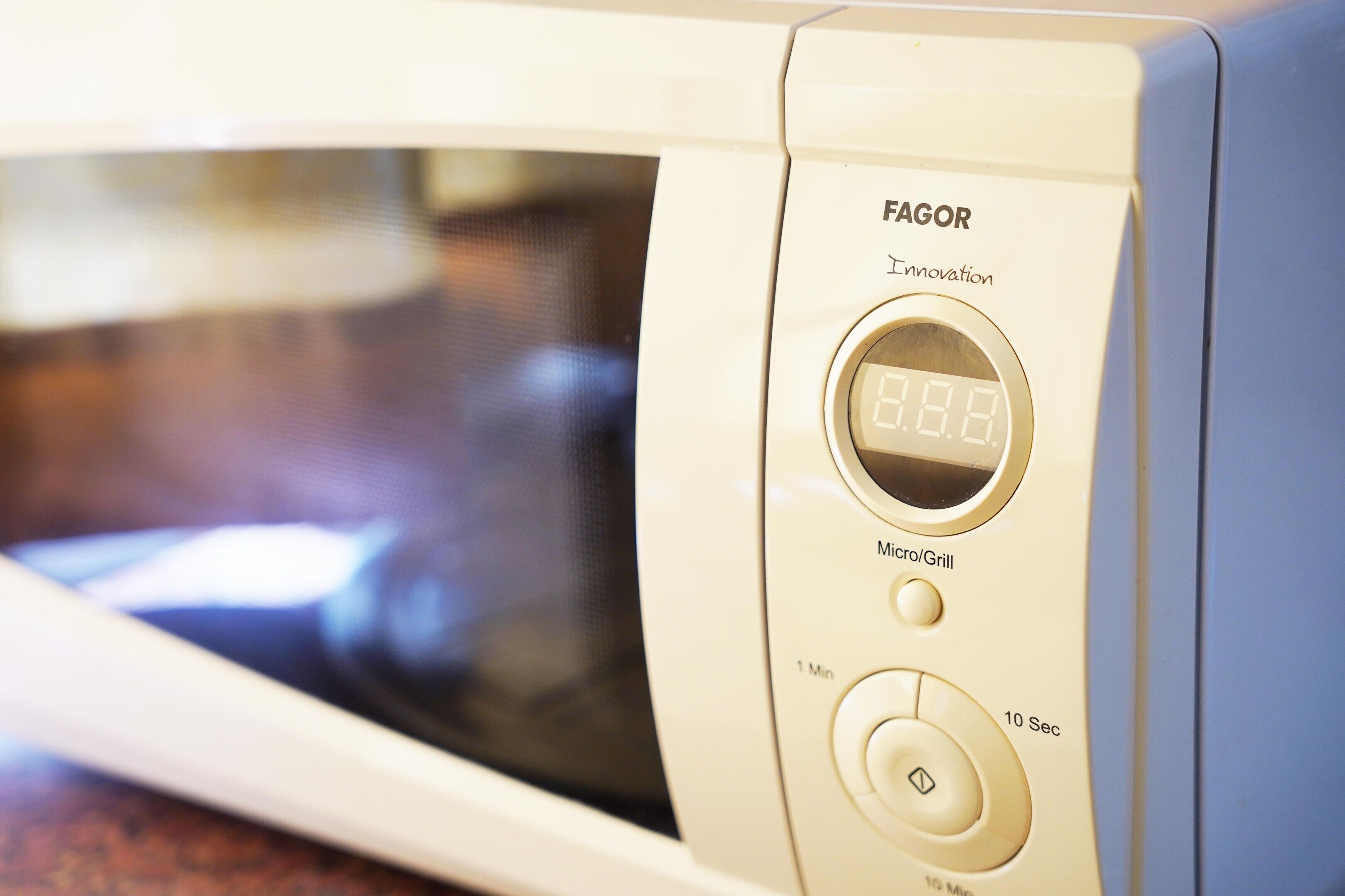 A microwave with a digital display, a timer, and a micro/groil button.