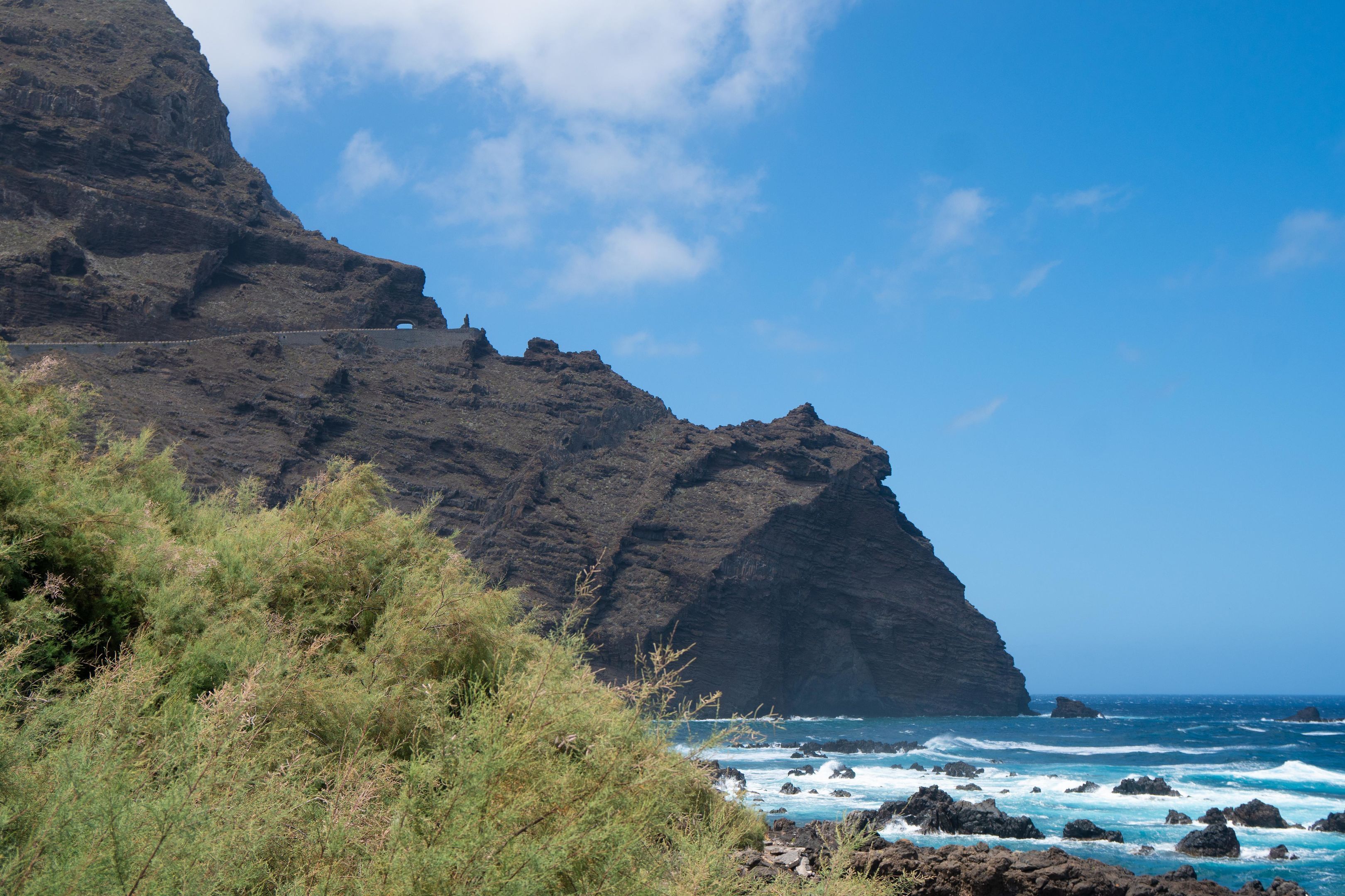 A coastal landscape with rocky cliffs and ocean waves.