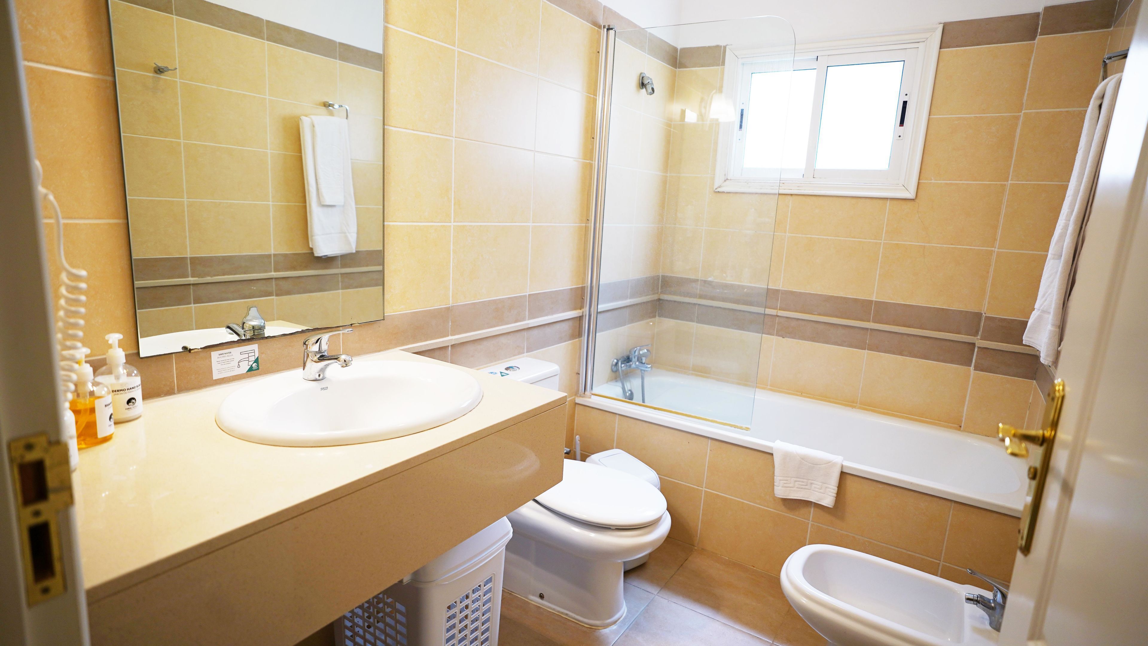 Une salle de bain équipée d’un lavabo, de toilettes, d’un bidet et d’une douche.