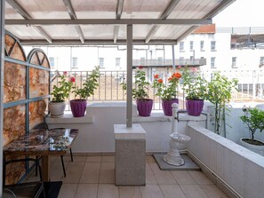 A balcony with potted plants, a marble table, and a white pedestal. - Ragıp Pasha Apartments (Istanbul)