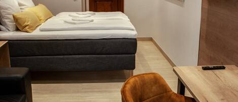Una habitación de hotel moderna con una cama, un escritorio, una silla y un televisor.