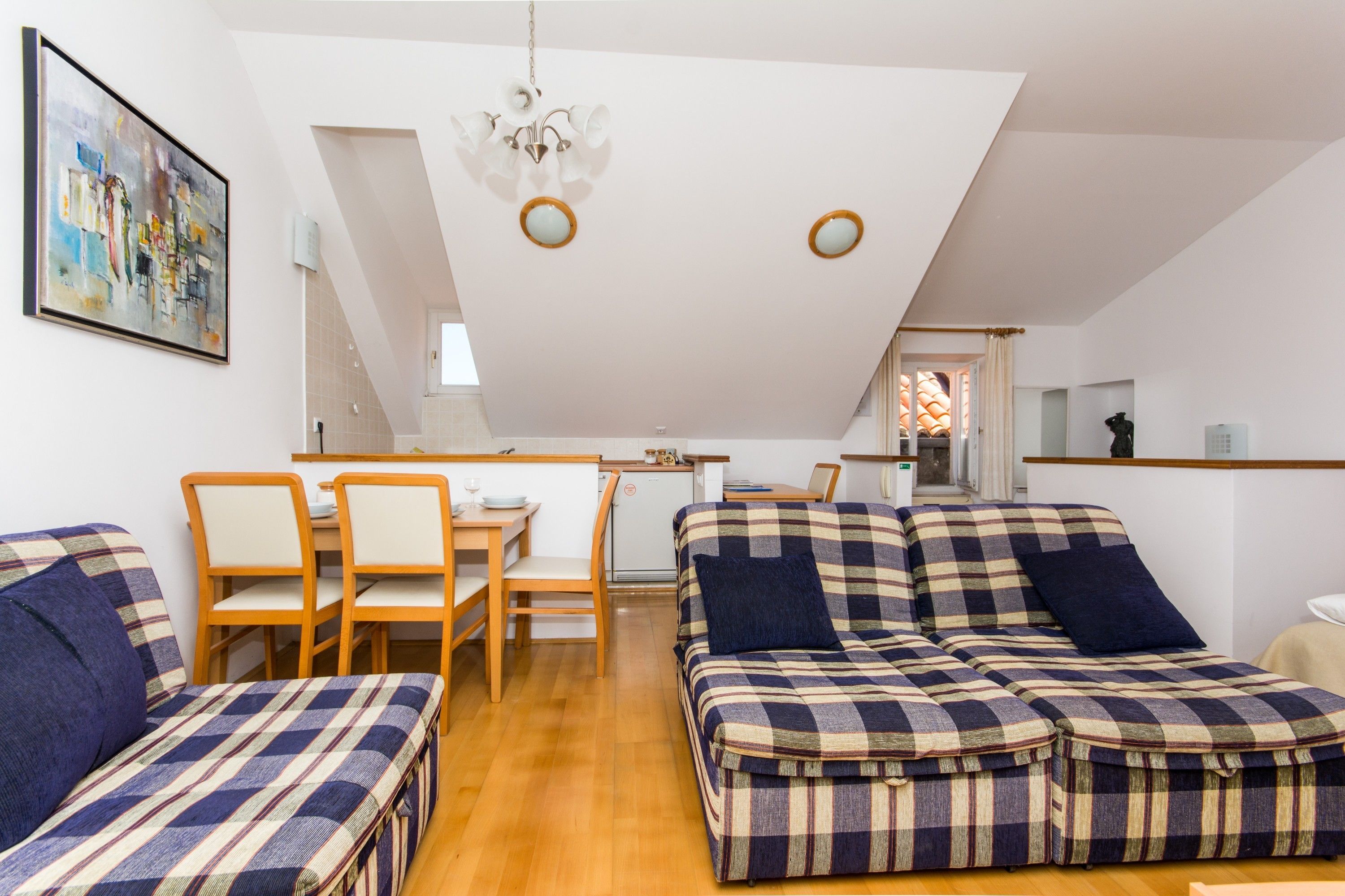 Un appartamento moderno con zona pranzo, divano e cucina.