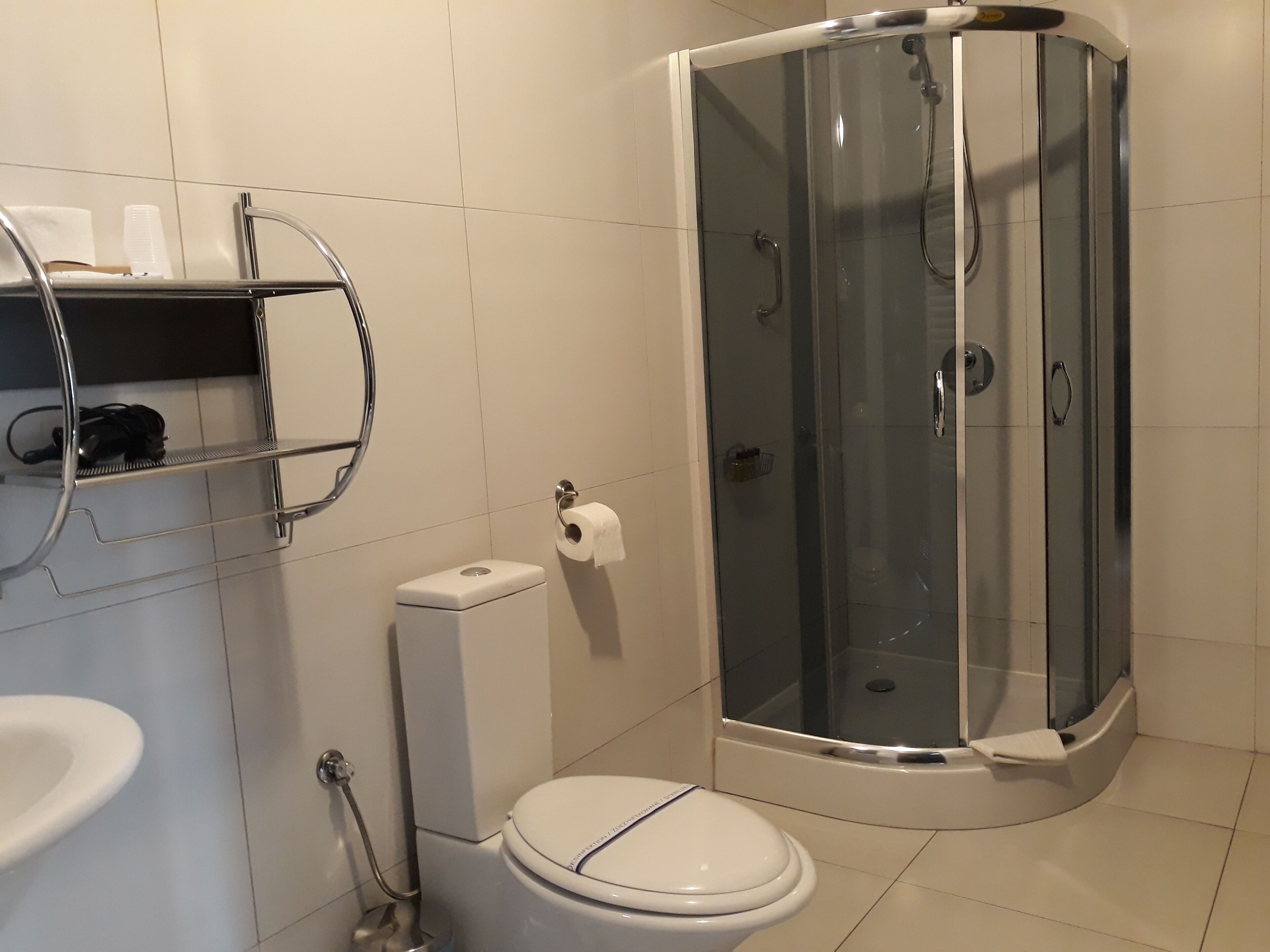Une salle de bain moderne avec une douche à parois de verre, des toilettes et un lavabo.
