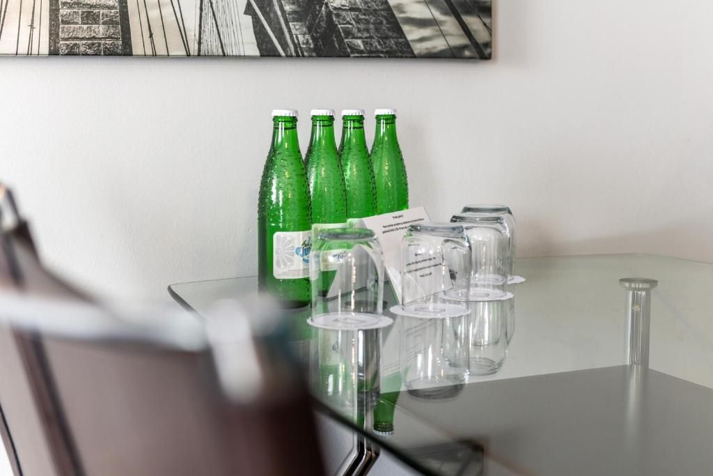 Ett glasbord med gröna flaskor och genomskinliga glas.