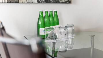 Ett glasbord med gröna flaskor och genomskinliga glas.