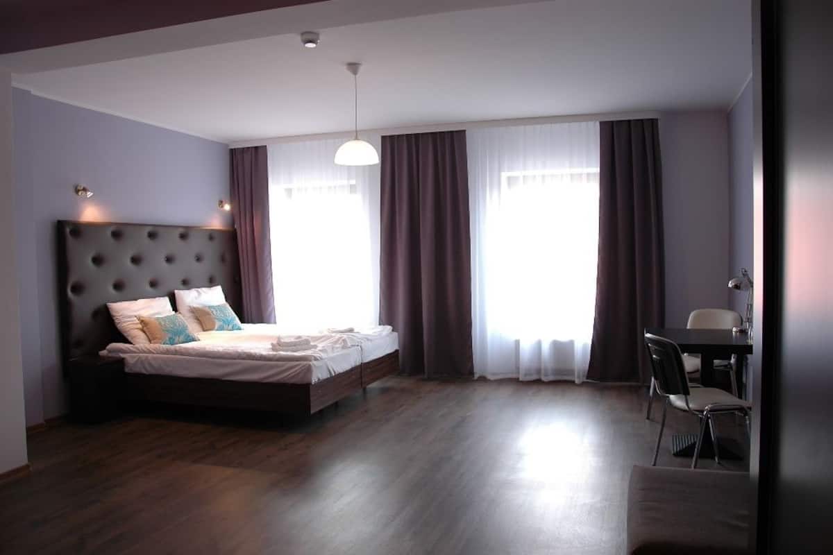Una habitación de hotel moderna con una cama grande, un escritorio y una silla.