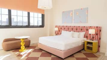 A bedroom with a bed, a sofa, a small table, and a nightstand.