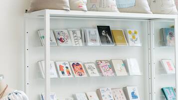 A white shelving unit with various greeting cards and a floral dress on display.