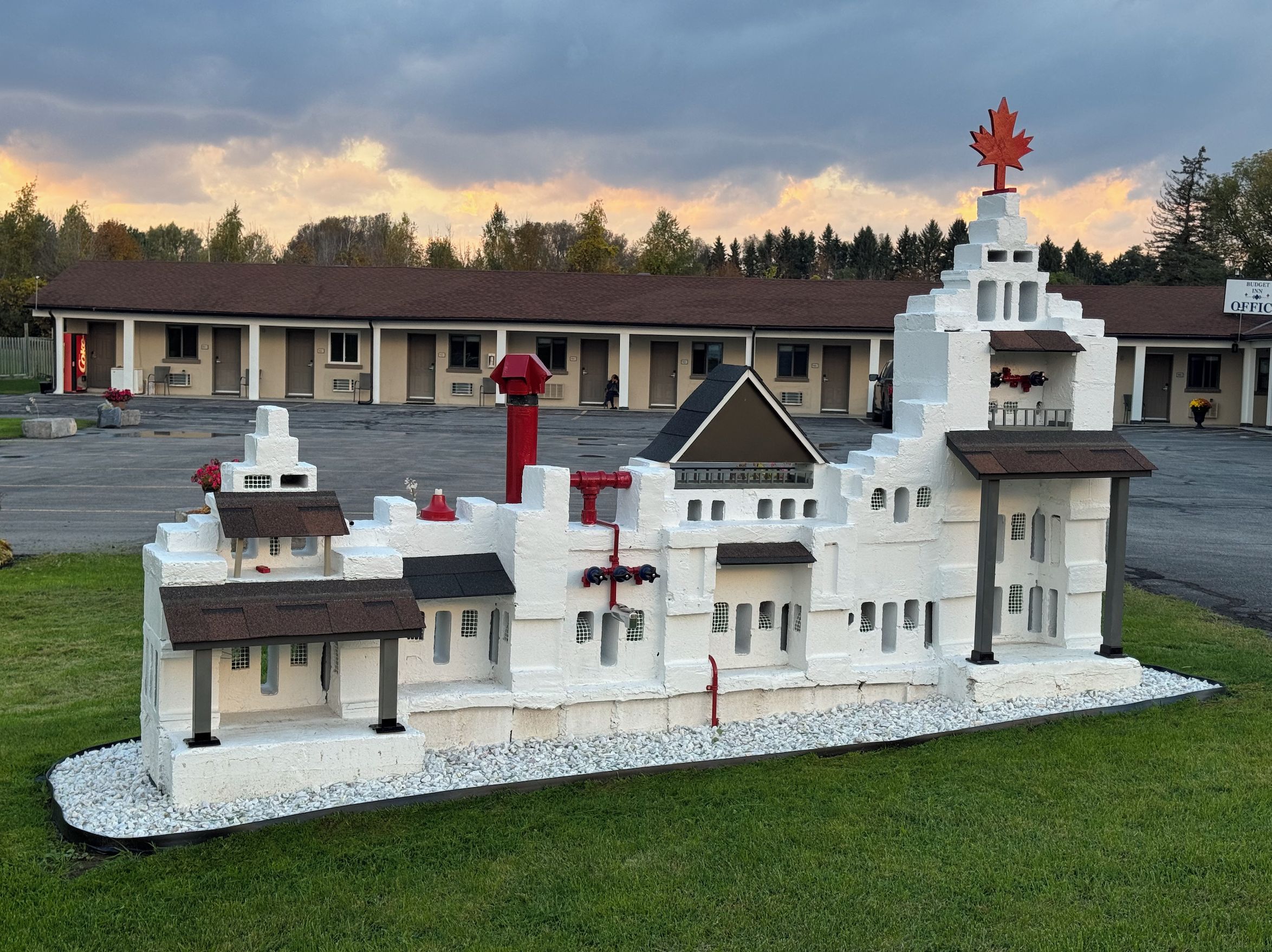 A model of a building with a prominent tower, a central entrance, and multiple smaller structures.