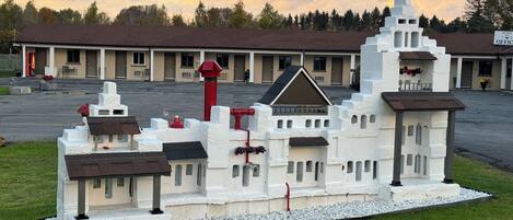 A model of a building with a prominent tower, a central entrance, and multiple smaller structures.