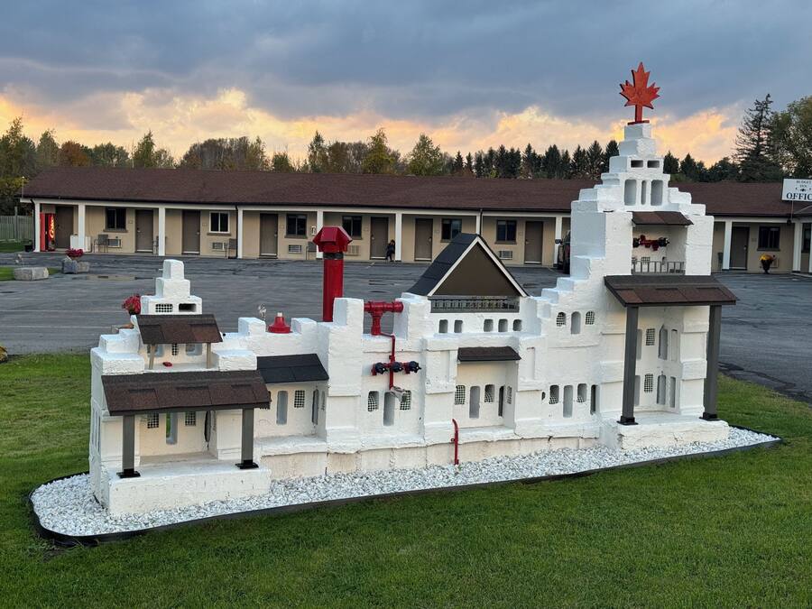 Ein Modell eines Gebäudes mit einem markanten Turm, einem zentralen Eingang und mehreren kleineren Bauten.