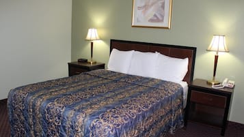 Habitación de hotel con una cama grande, dos mesitas de noche con lámparas y un cuadro abstracto enmarcado en la pared.