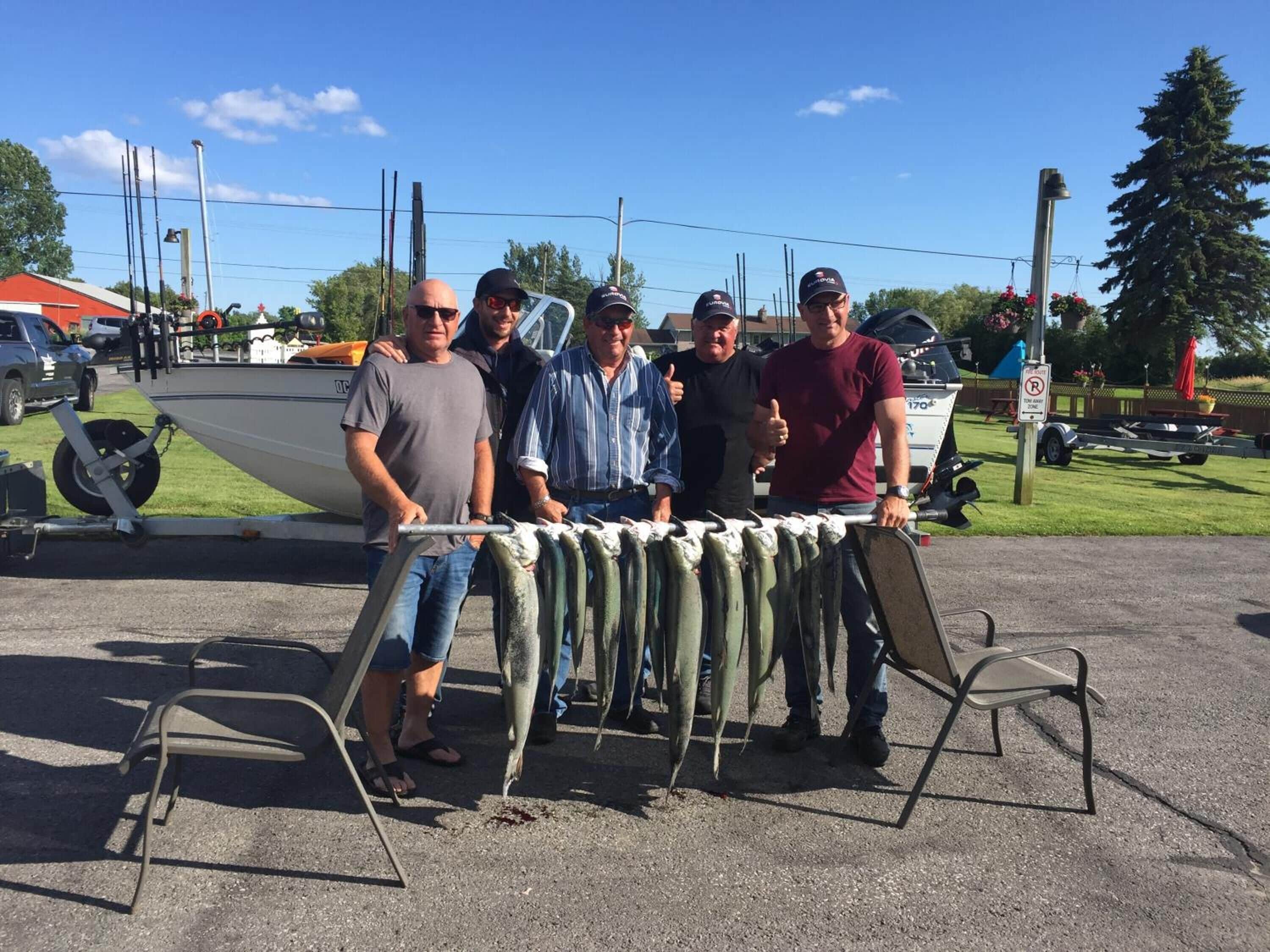 Un grupo de personas de pie detrás de una mesa con pescado exhibido.