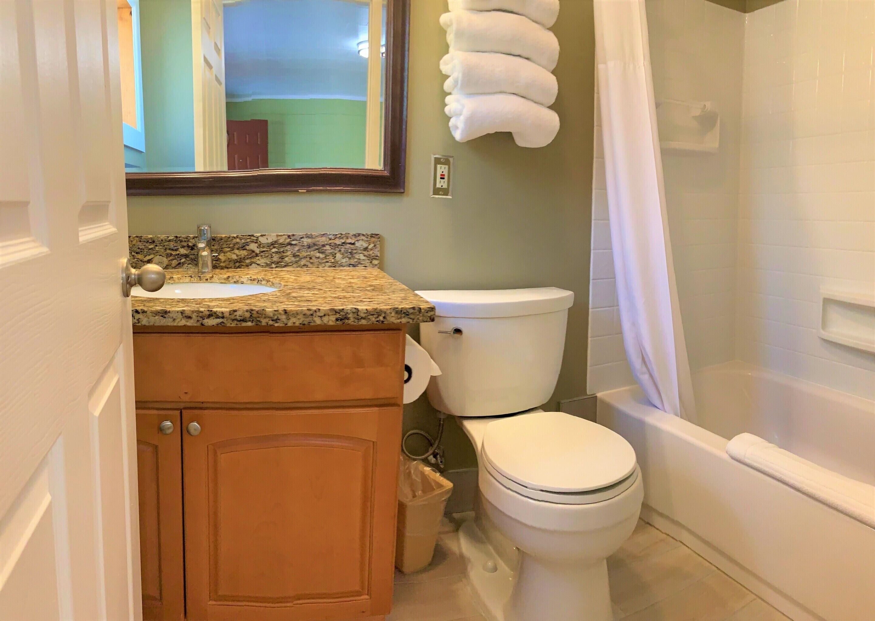 A bathroom with a sink, toilet, and shower.
