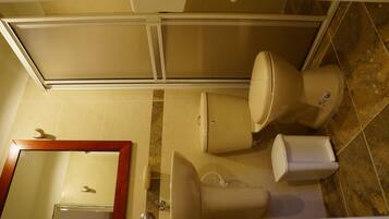 A bathroom with a toilet, bidet, and sink.