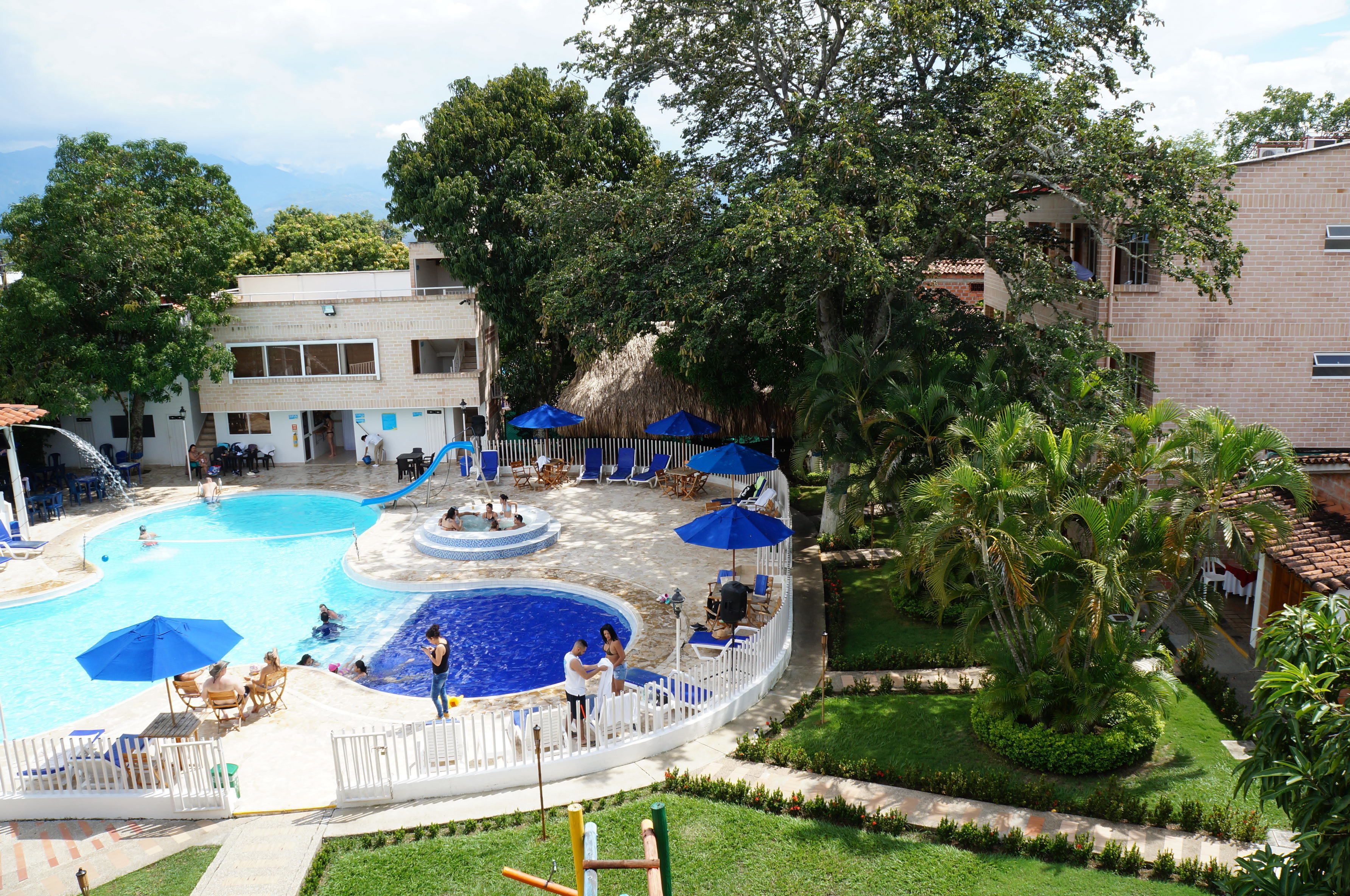 Una piscina con bordo circostante, lettini e ombrelloni.