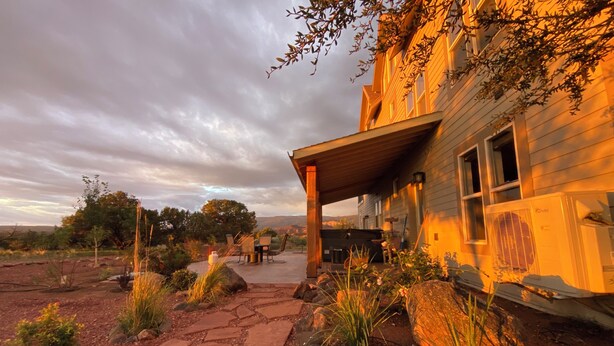 A rustic building with a stone pathway leading to a covered patio area.