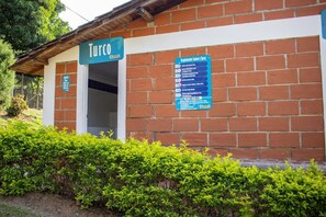 En byggnad med en skylt där det står ”Turco” och en blå skylt med information om reglerna för bastu och turkiskt bad.