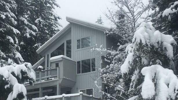 A two-story building with a balcony, surrounded by snow-covered trees. - Belle Neige Suites- Whistler (Whistler)