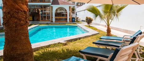Alberca al aire libre y camastros
