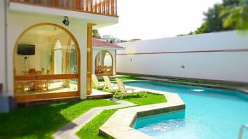 Alberca al aire libre y camastros