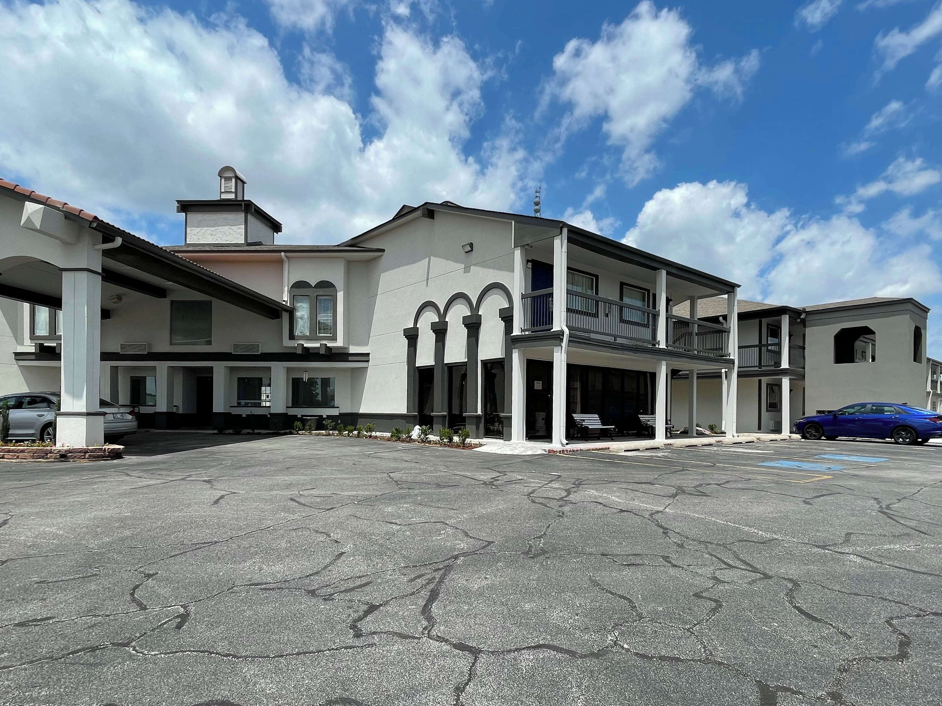 A two-story building with a covered front porch and a parking lot.