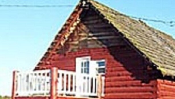 A red wooden barn with a porch and a small window. - Attwood Creek Ranch (Lone Butte)
