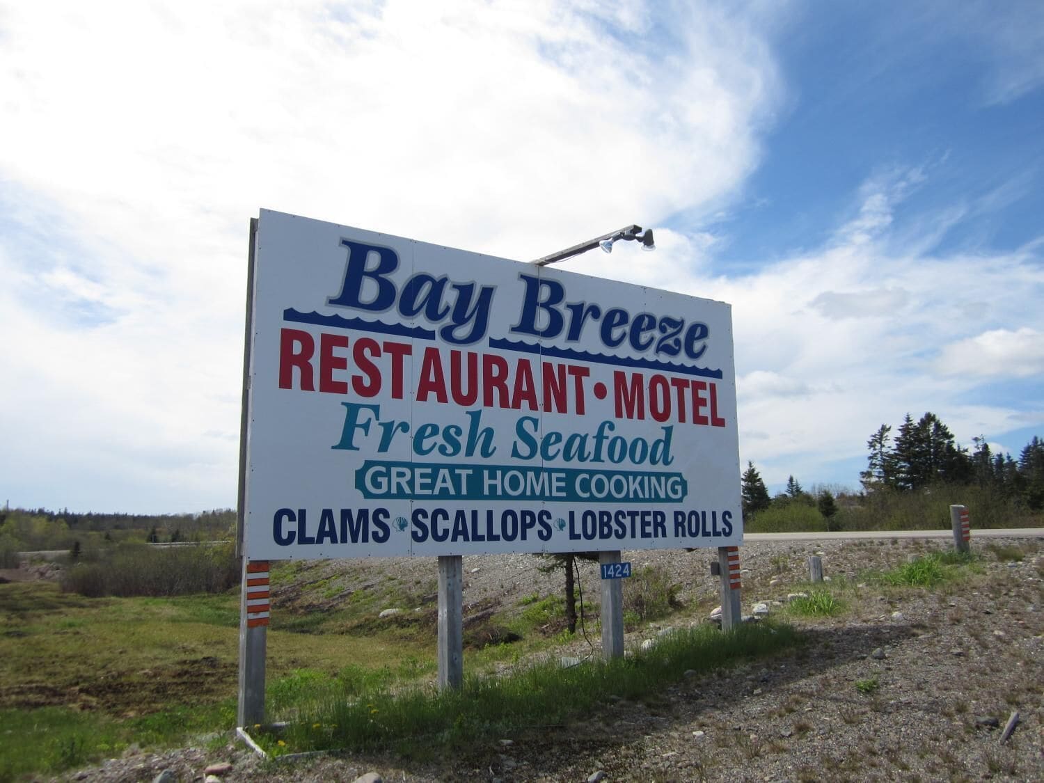A sign for Bay Breeze Restaurant & Motel advertising fresh seafood and home cooking.