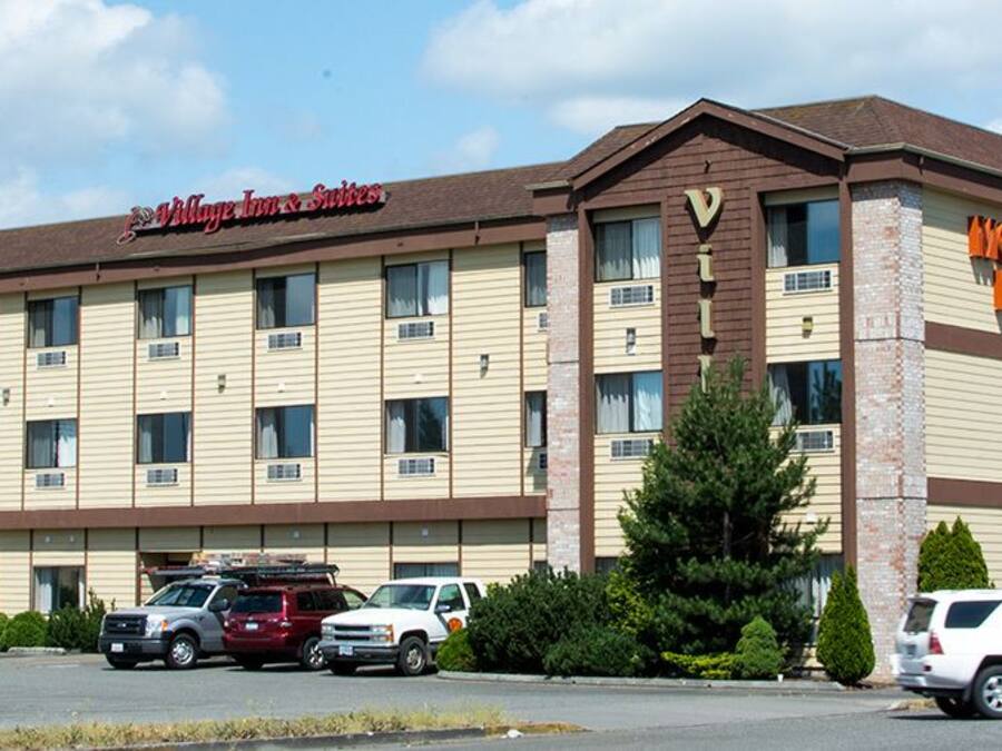 Un hotel con fachada color beige, numerosas ventanas y un letrero que dice "Holiday Inn & Suites".