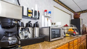 Eine Küchenzeile mit Kaffeemaschine, Mikrowelle, Toaster und verschiedenen Küchengeräten.