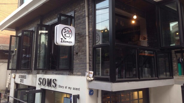 Een gebouw met een bord voor 'Japanese Food Ikemen' en een ander voor 'SOMS Story of my scent'.