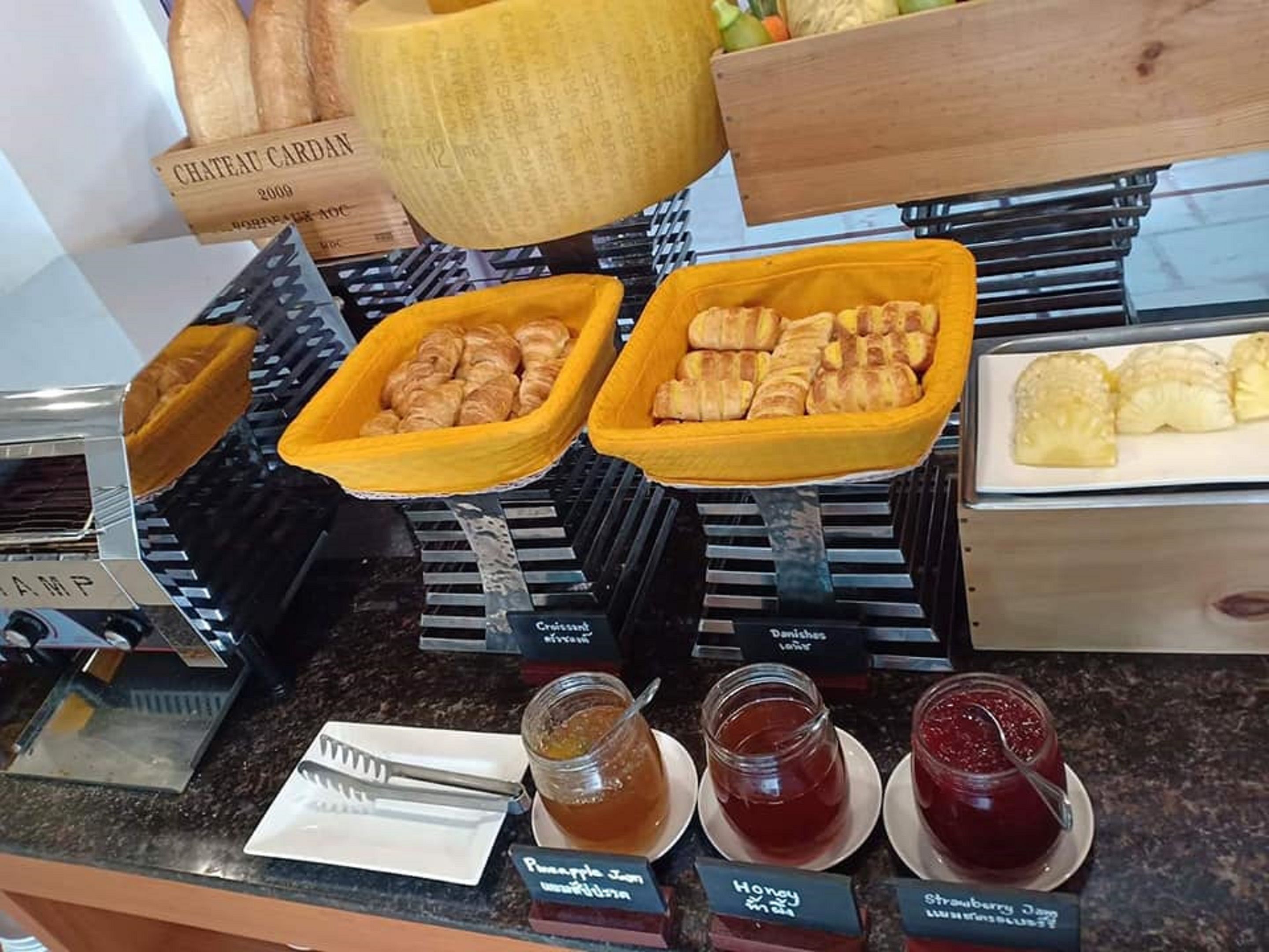 A bakery display with various pastries and jars of preserves.