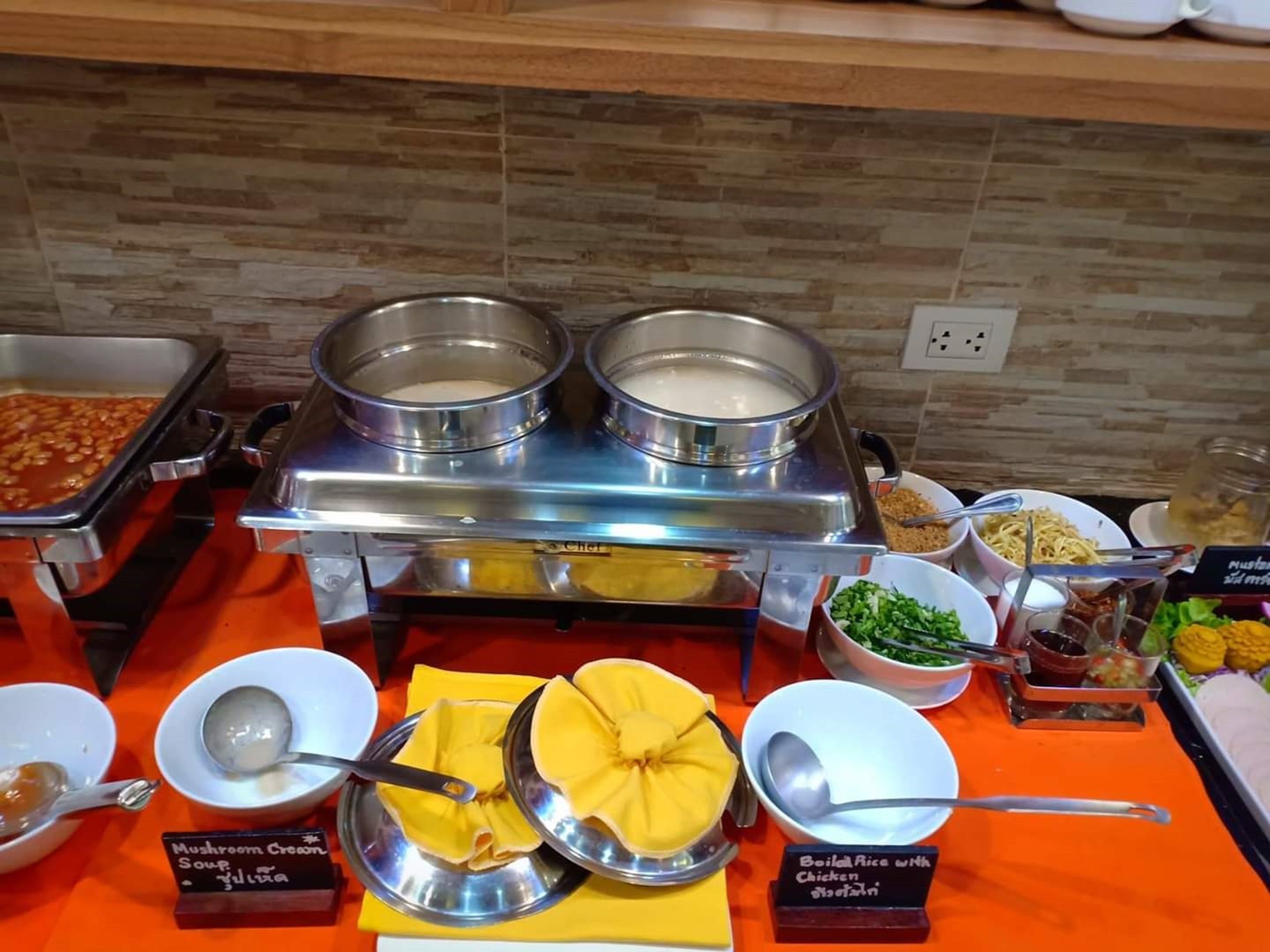 A buffet with various dishes including Mushroom Cream Soup, Boiled Rice with Chicken, and other items.