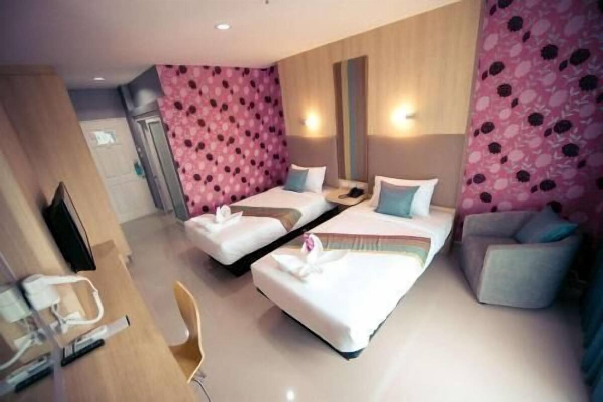Una habitación de hotel con dos camas, un sofá, un escritorio y una silla.