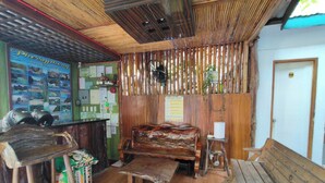Un interior rústico con un banco de madera, una mesa y una pared decorada con carteles de viajes.
