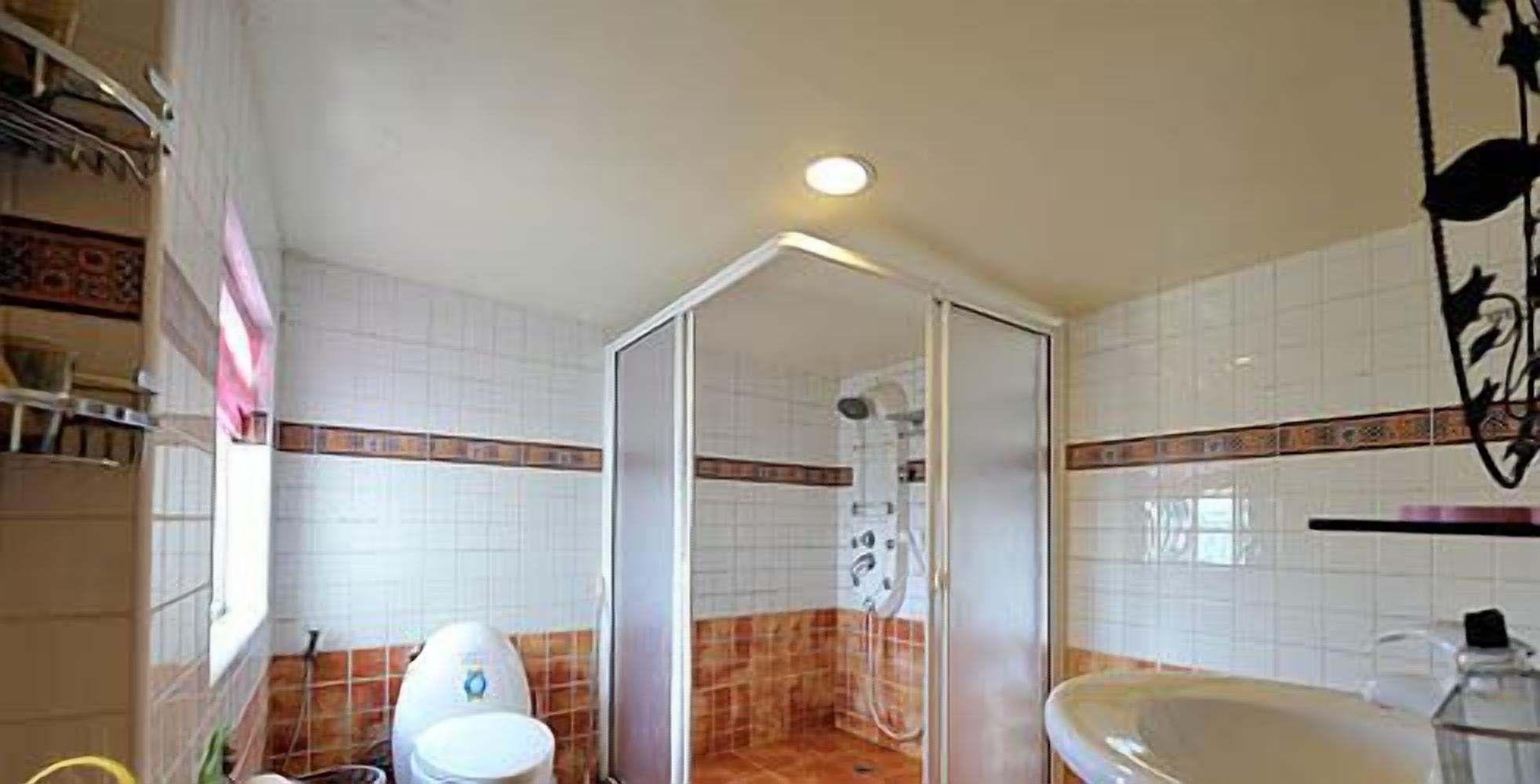 A bathroom with a shower, toilet, and sink.