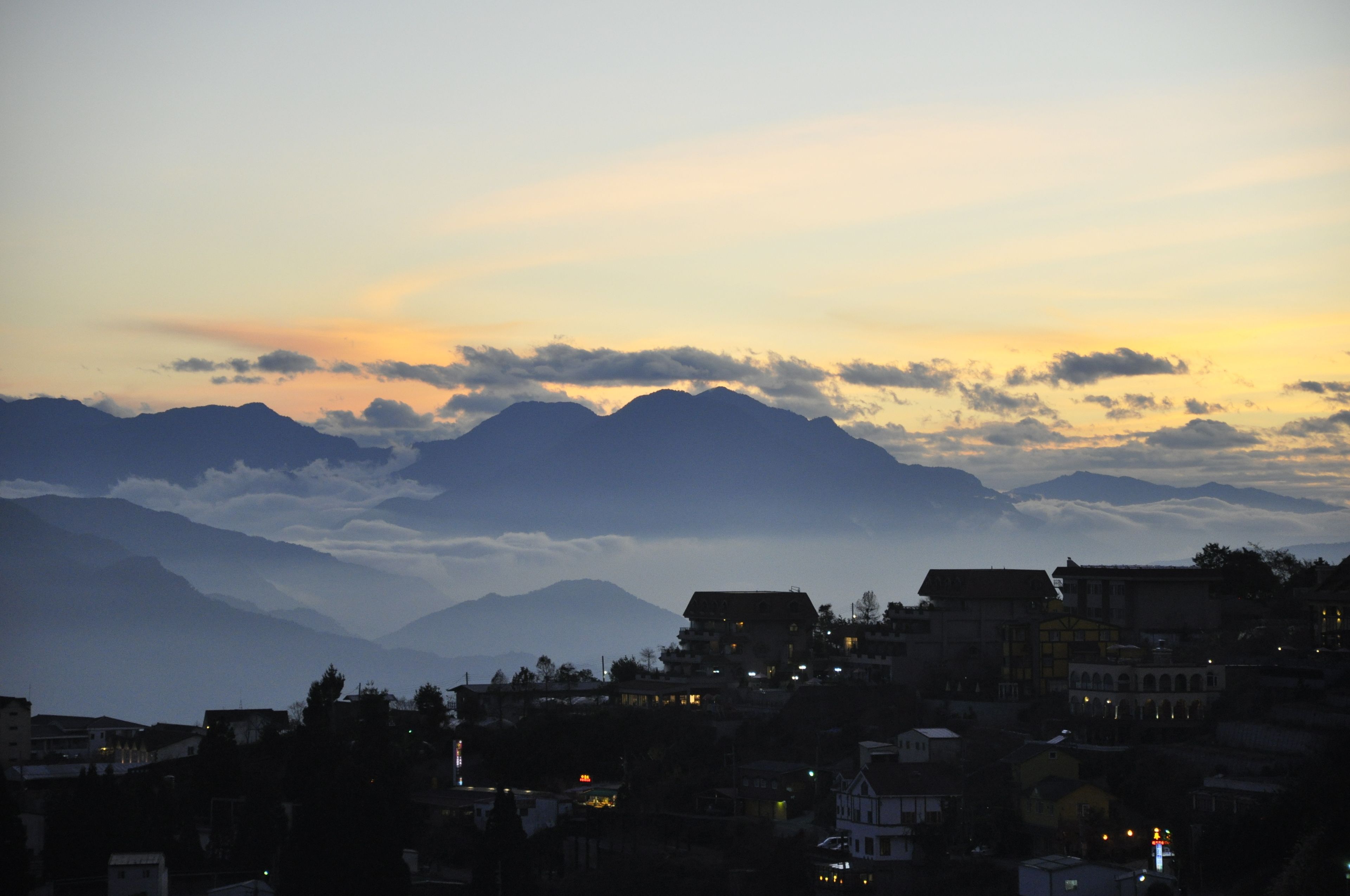 A mountainous landscape with a town in the foreground.