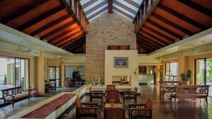 A spacious lobby with high ceilings, a stone fireplace, and multiple seating areas.