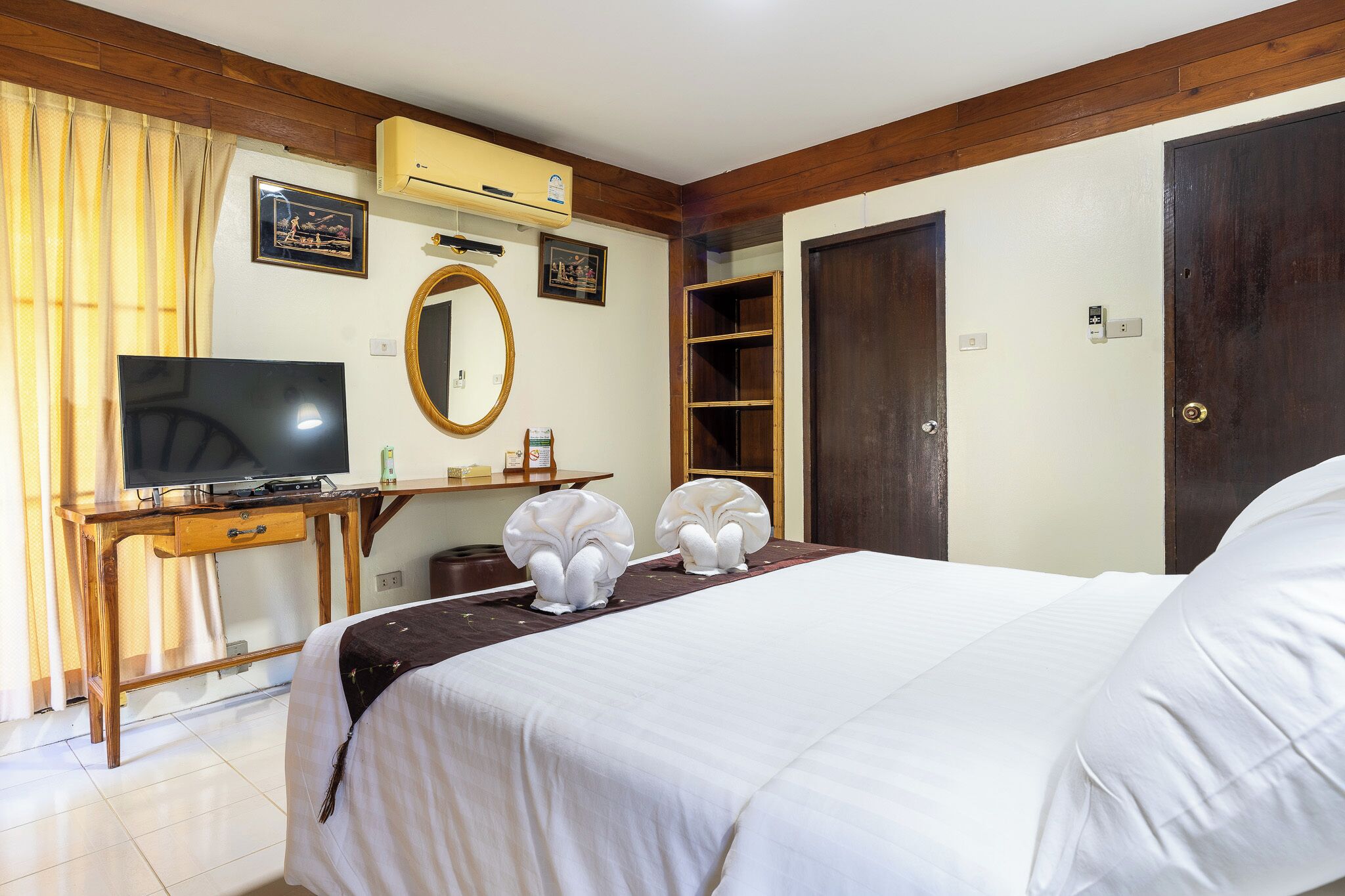 A hotel room with a bed, a TV, a desk, and a wardrobe.