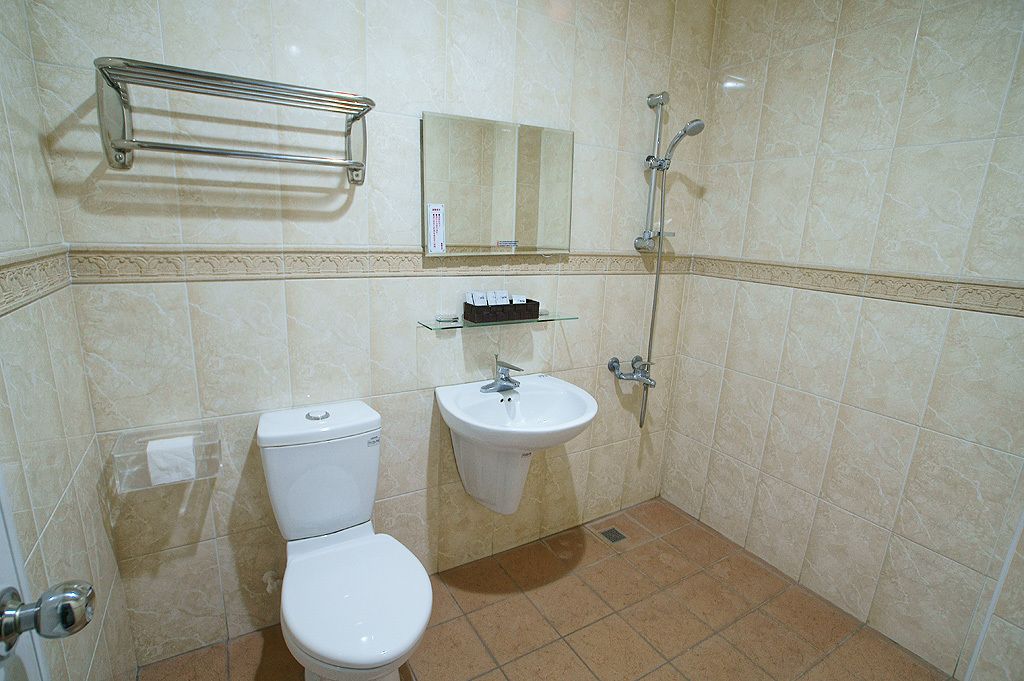 Un baño con inodoro, lavamanos y ducha.
