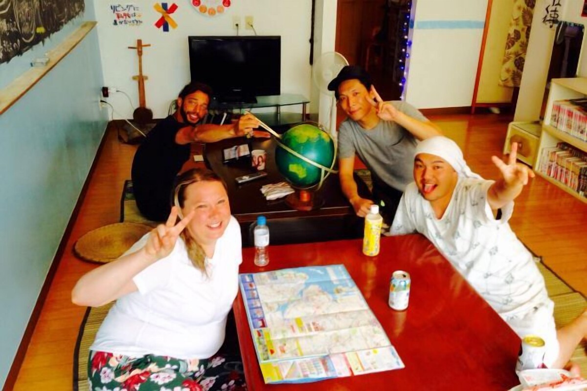 A group of people sitting around a table with a globe, a map, and some snacks.