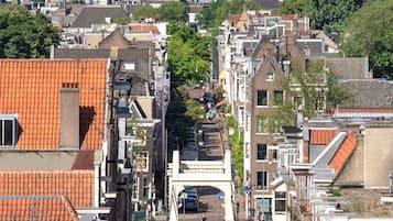 Straatbeeld met historische gebouwen, een heldere lucht en geparkeerde auto's.
