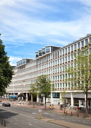 A modern multi-story building with a grid-like facade, large windows, and a flat roof. - Zoku Amsterdam (Amsterdam)