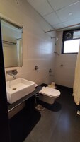 Un bagno moderno con un lavandino bianco, un water e una doccia.