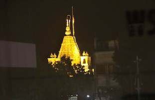 A building with a golden spire and a flagpole.
