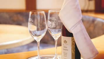 A bottle of wine with a white napkin on a tray, accompanied by two empty wine glasses.