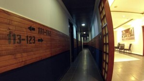 A hallway with directional signs indicating room numbers 113-123 and 111-112. - Tiberias Hostel (Tiberias)