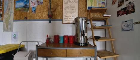 Una kitchenette con cafetera, un mapa y varias fotos en la pared.