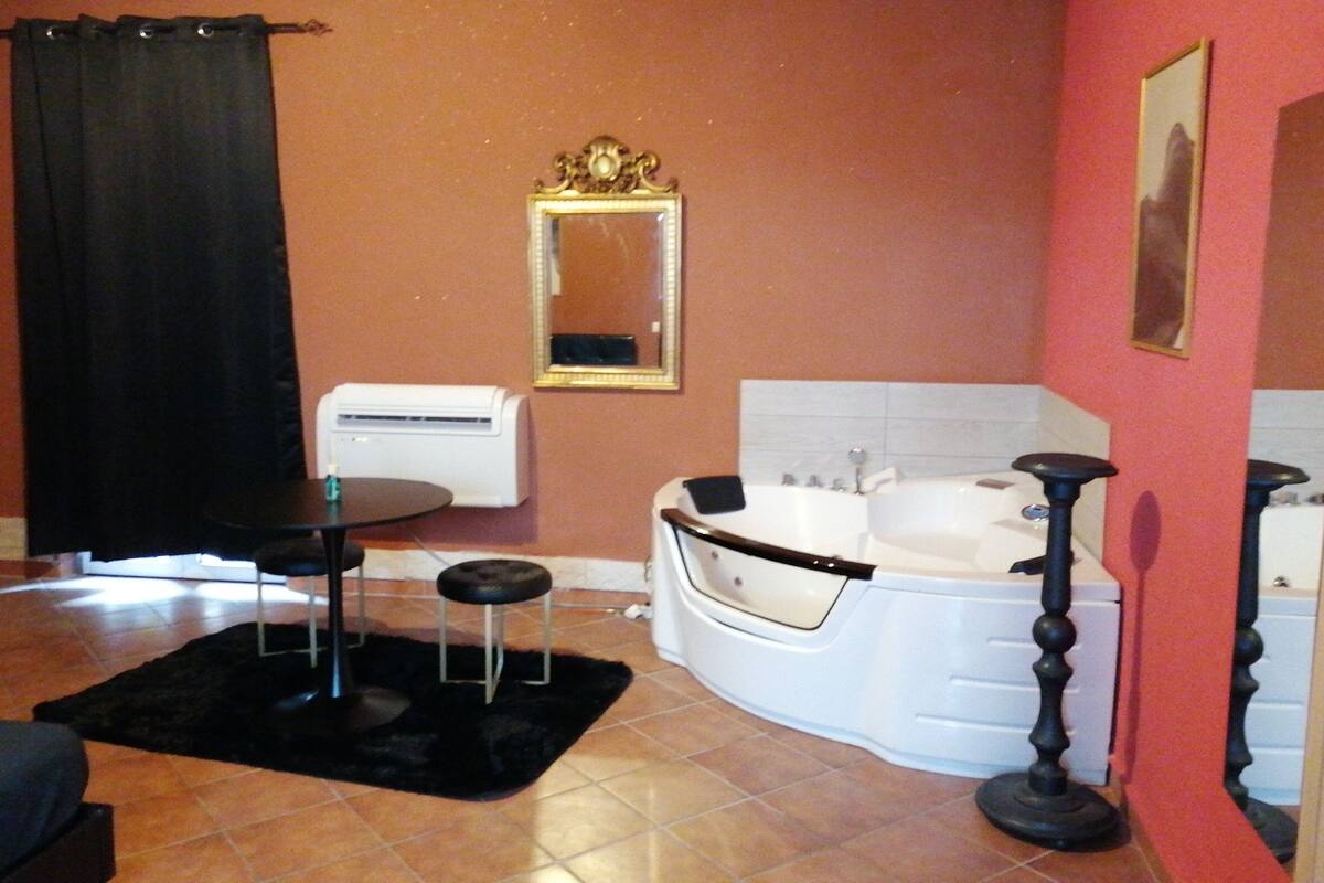 A bathroom with a bathtub, a sink, and a mirror.
