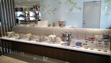 A buffet setup with various food items and a coffee station.